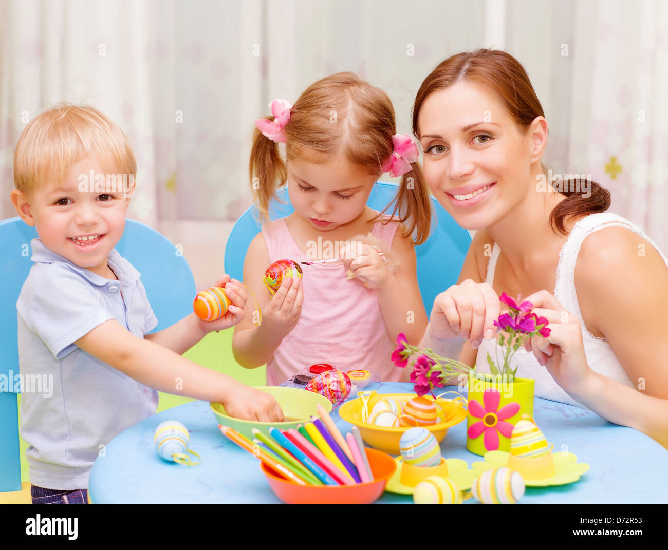 Zwei süße Kleinkind mit jungen Zeichenlehrer malen bunte Ostereier, Kunstunterricht, handgemachte festliche Dekoration Stockfoto