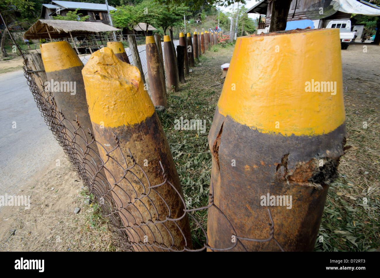 Unexploded Ordnance Fence Plain of Jars Provinz Xiengkhouang Laos // PROVINZ XIENGKHOUANG, Laos — Ein Munitionszaun aus nicht explodierten Kampfmitteln (UXO) umgibt ein Feld in der Plain of Jars Region. Der Secret war, der von den Vereinigten Staaten von 1964 bis 1973 während des größeren Vietnamkrieges geführt wurde, führte zu umfangreichen Bombenangriffen, die Laos zu den am stärksten bombardierten Ländern der Geschichte machten. Diese Umnutzung gefährlicher Überreste spiegelt die lokale Anpassung an das anhaltende Vorhandensein von nicht explodierter Munition wider, die über die Landschaft verstreut ist. Die Ebene der Gläser, bekannt für sie Stockfoto