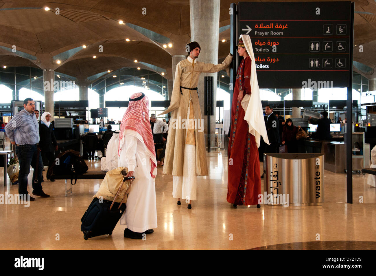 Jordanien, Amman. Queen Alia International Airport. Stelzenläufer  unterhalten Passagiere Stockfotografie - Alamy