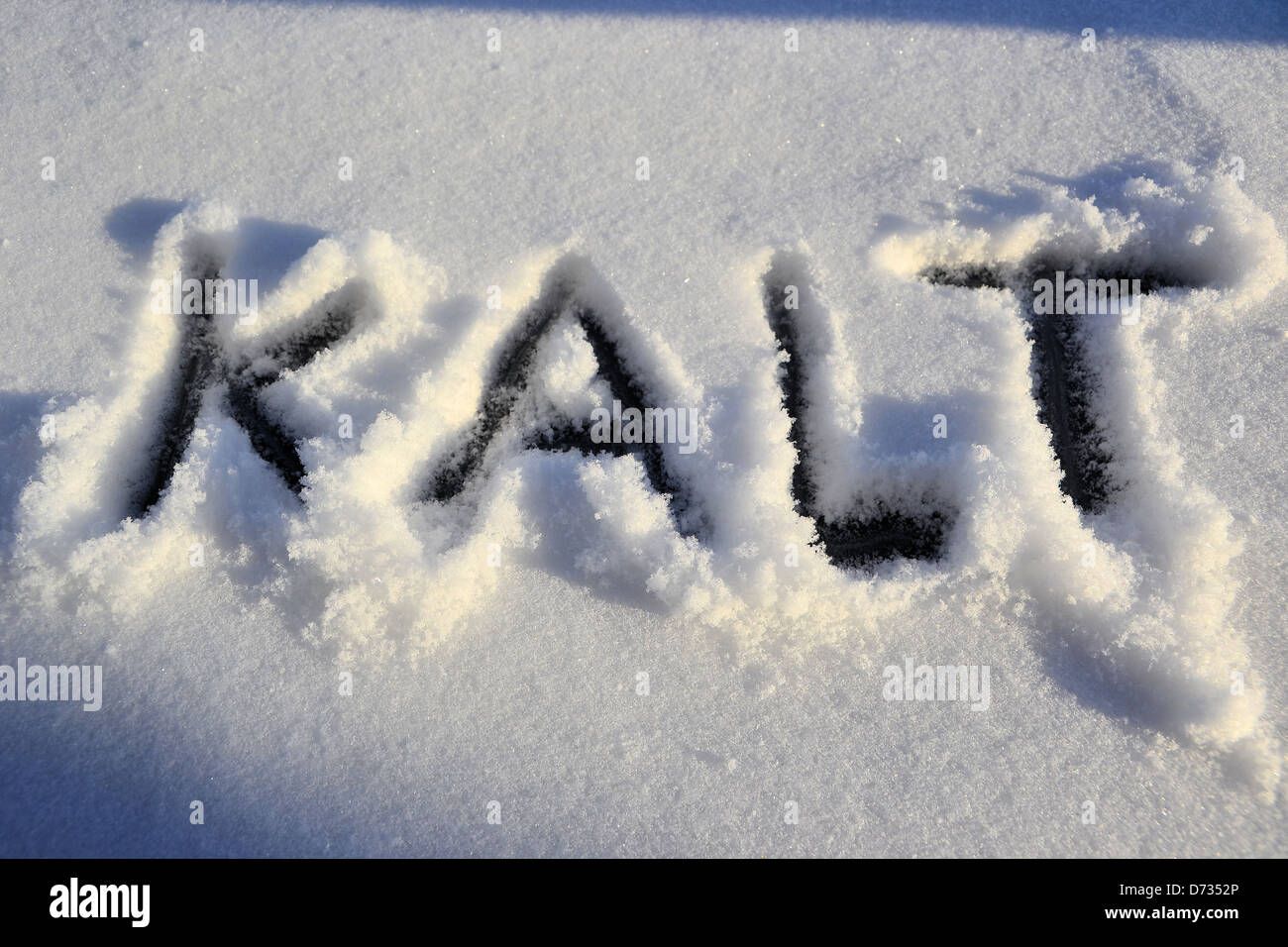 Das Wort kalt ist in den Schnee geschrieben. Stockfoto