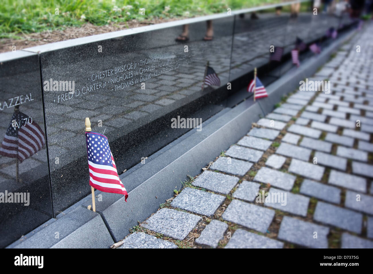 Amerikanische Flaggen stehen an der Basis der Mauer bei der Vietnam Veterans Memorial Stockfoto