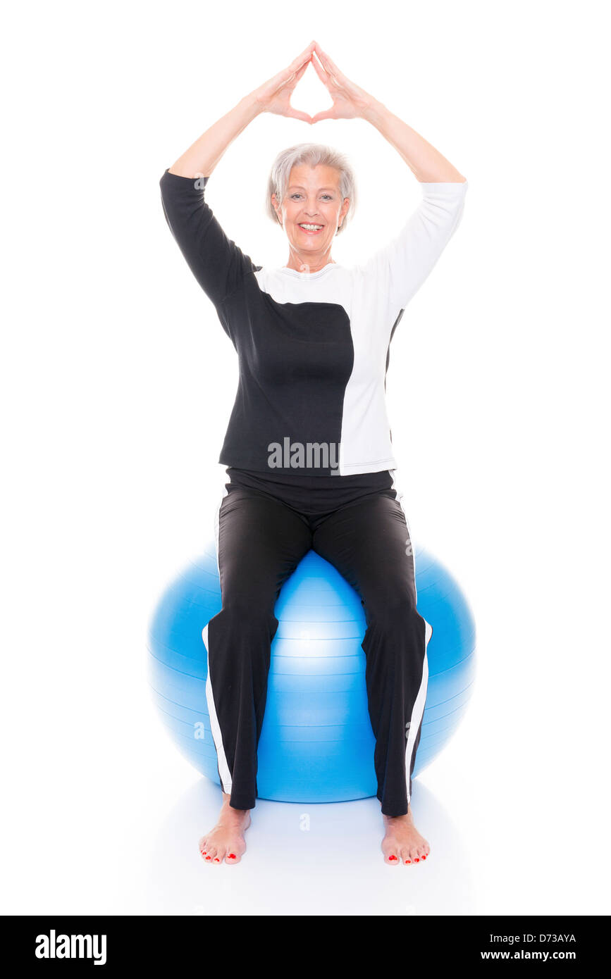 Ältere Frau mit Gymnastik Ball vor weißem Hintergrund Stockfoto