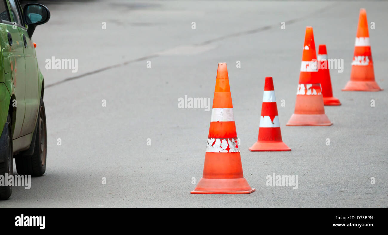 Gestreifte orangen Kegeln auf der Asphaltstraße Stockfoto