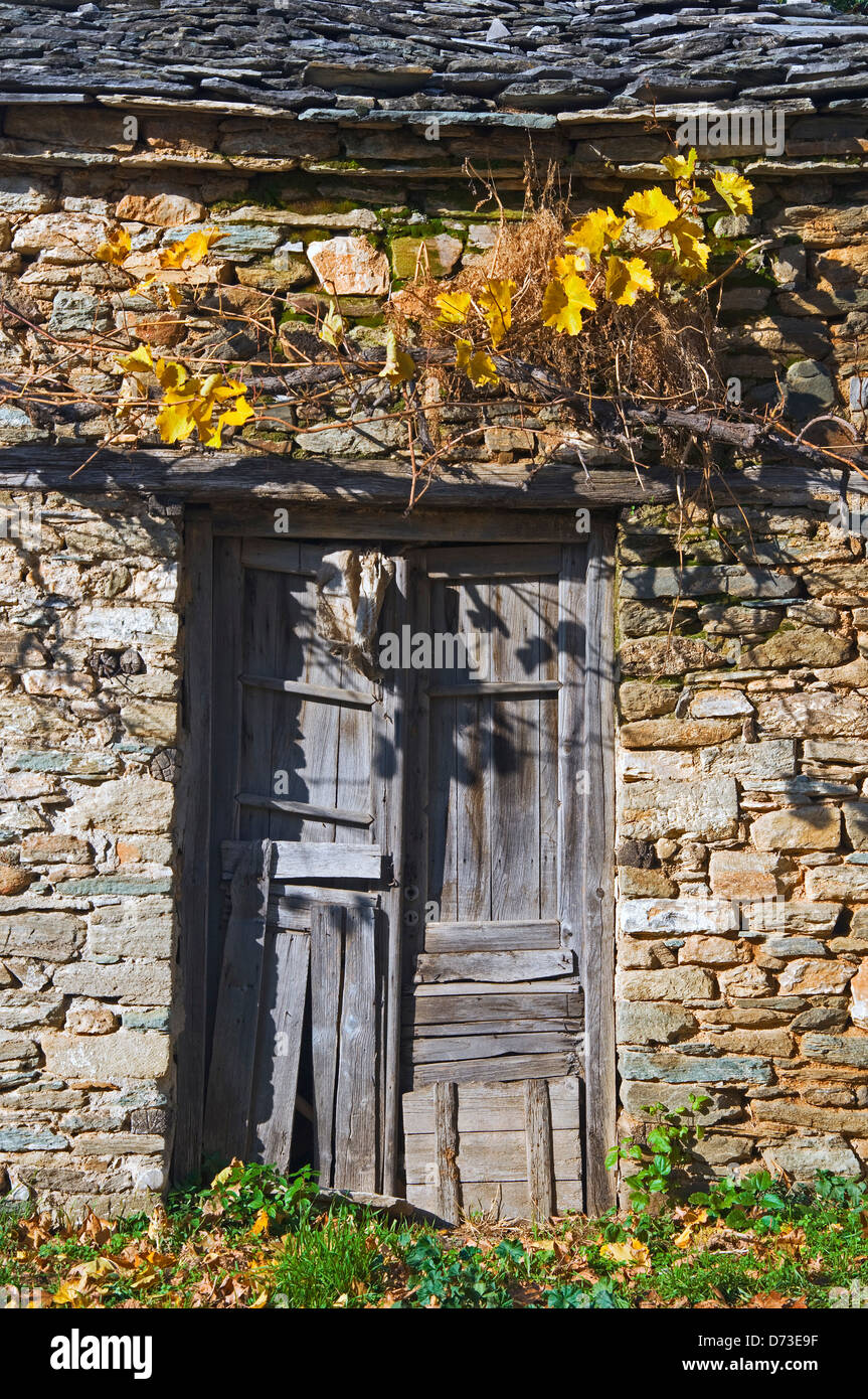 Marode hölzerne Tür im alten Steinhaus-front Stockfoto