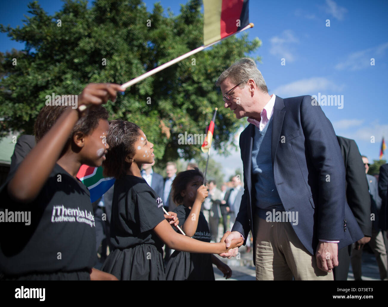 Der deutsche Außenminister Guido Westerwelle wird von Kindern im Township Philippi in Cape Town, South Africa, 28. April 2013 begrüßt. Westerwelle besucht die iThemba Labantu lutherischen Gemeindezentrum bei seinem fünf-Tages-Besuch nach Afrika. Foto: MICHAEL KAPPELER Stockfoto