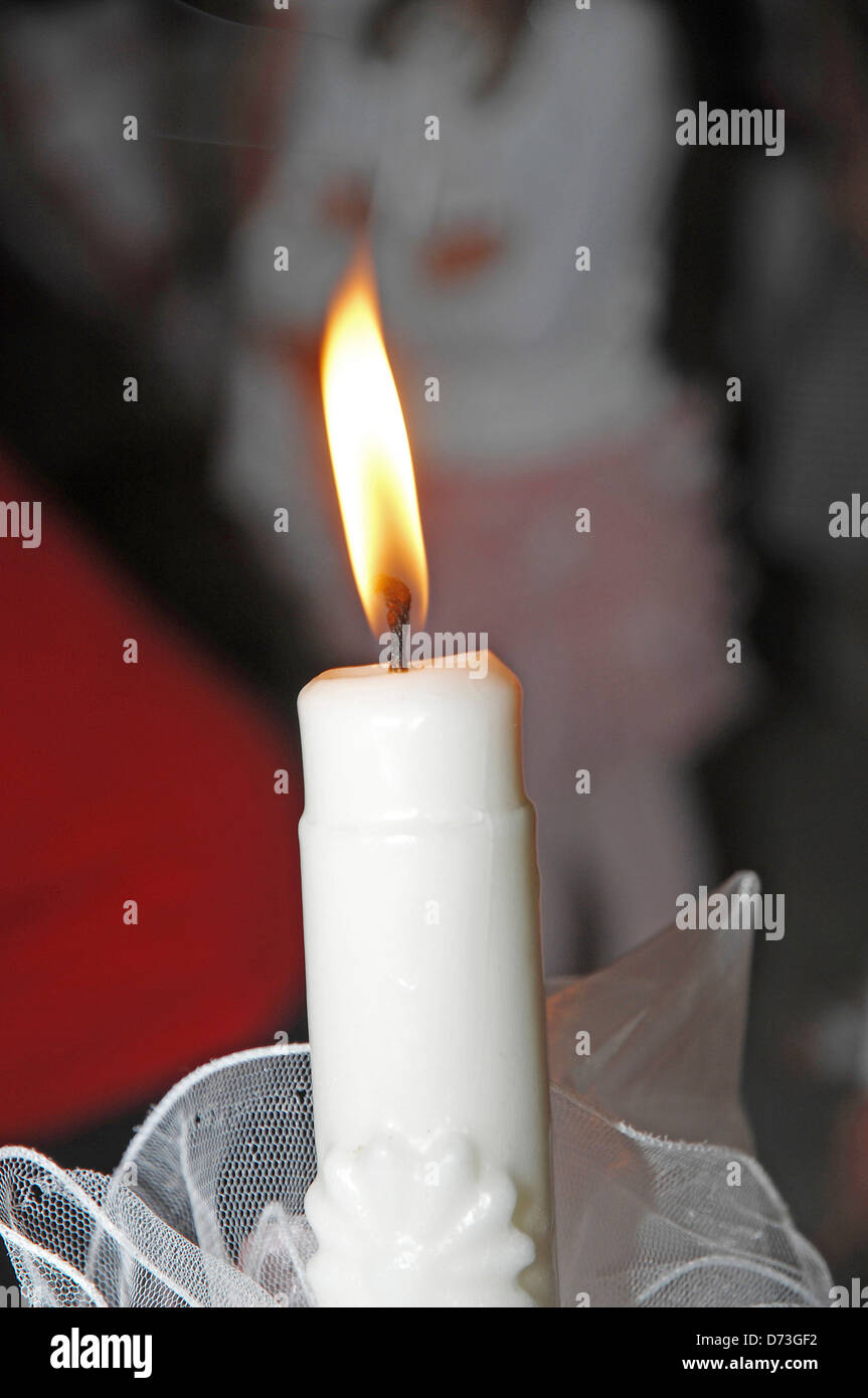 Beleuchtete Taufe Kerze Stockfoto