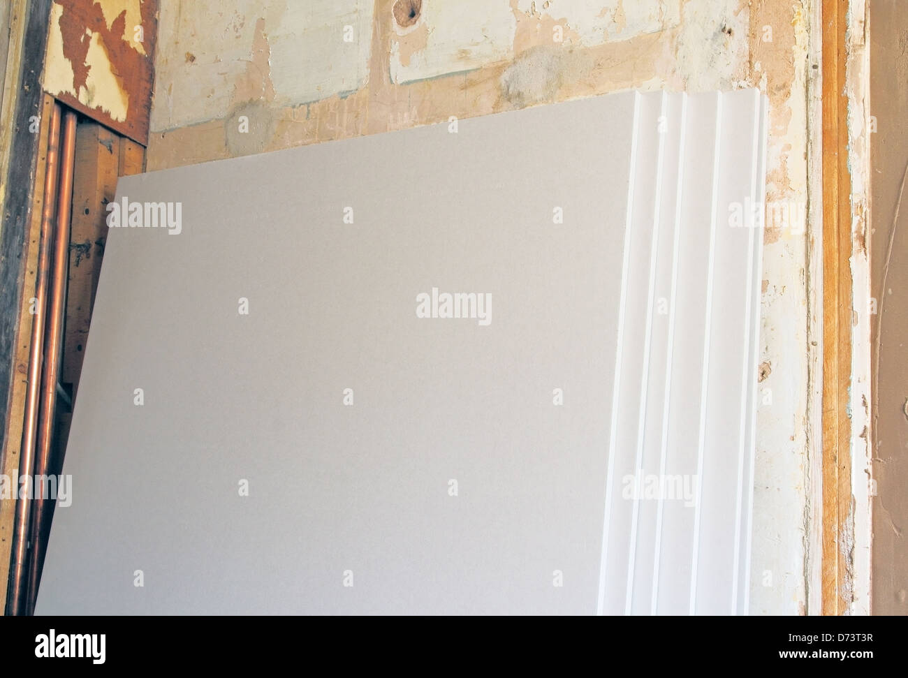 Platten aus Gipskarton gestapelt gegen eine Innenwand im Rahmen des Home Renovierung Eigentum veröffentlicht Stockfoto