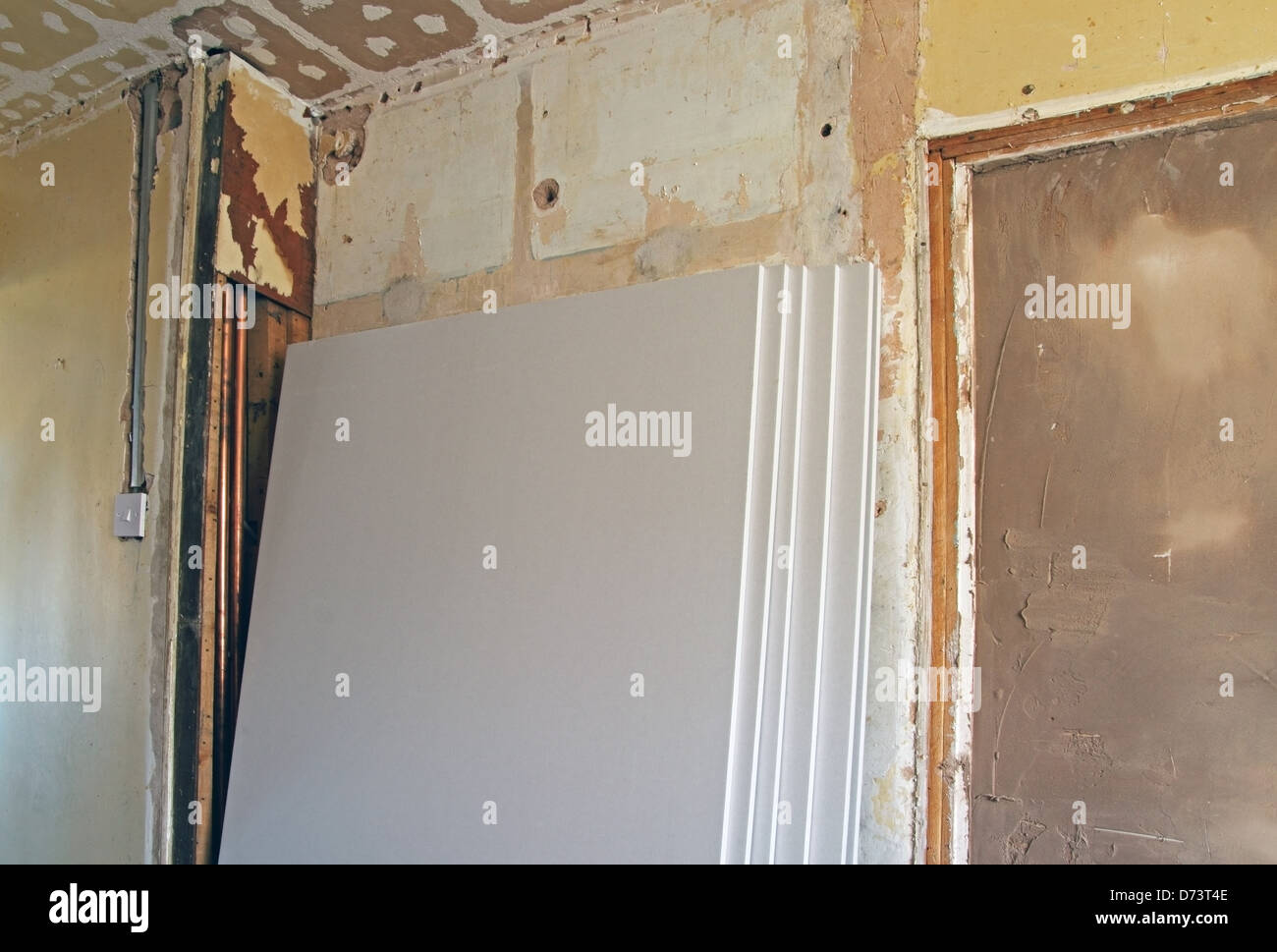 Platten aus Gipskarton gestapelt gegen eine Innenwand im Rahmen des Home Renovierung Eigentum veröffentlicht Stockfoto