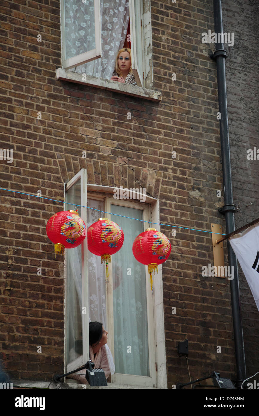 Zwei Frauen, die aus dem Fenster der Wohnung in London Chinatown Stockfoto