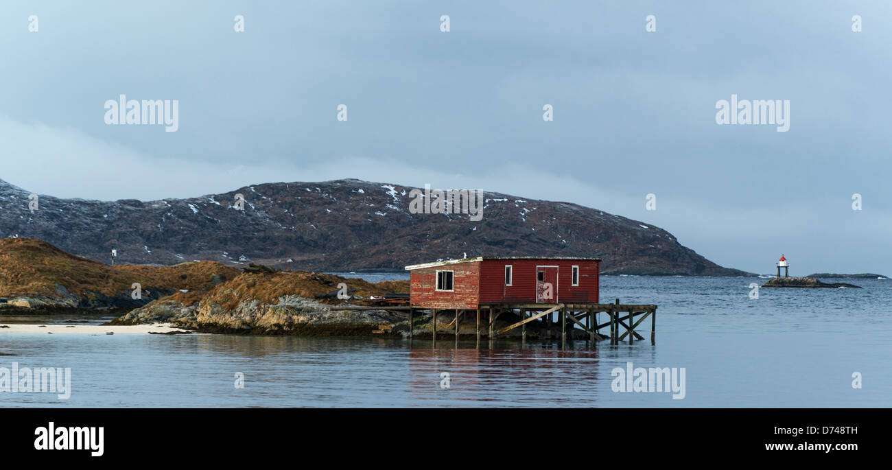 Hütte auf einer kleinen Insel in Sommarøy, Norwegen, mit einem kleinen Leuchtturm in der Ferne Stockfoto