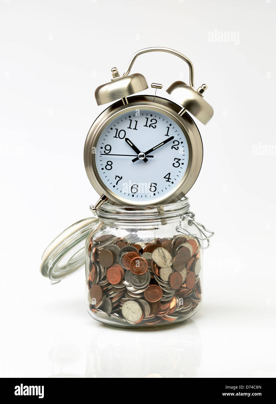 Zeit ist Geld, Uhr und Glas voller Münzen auf weißem Hintergrund Stockfoto