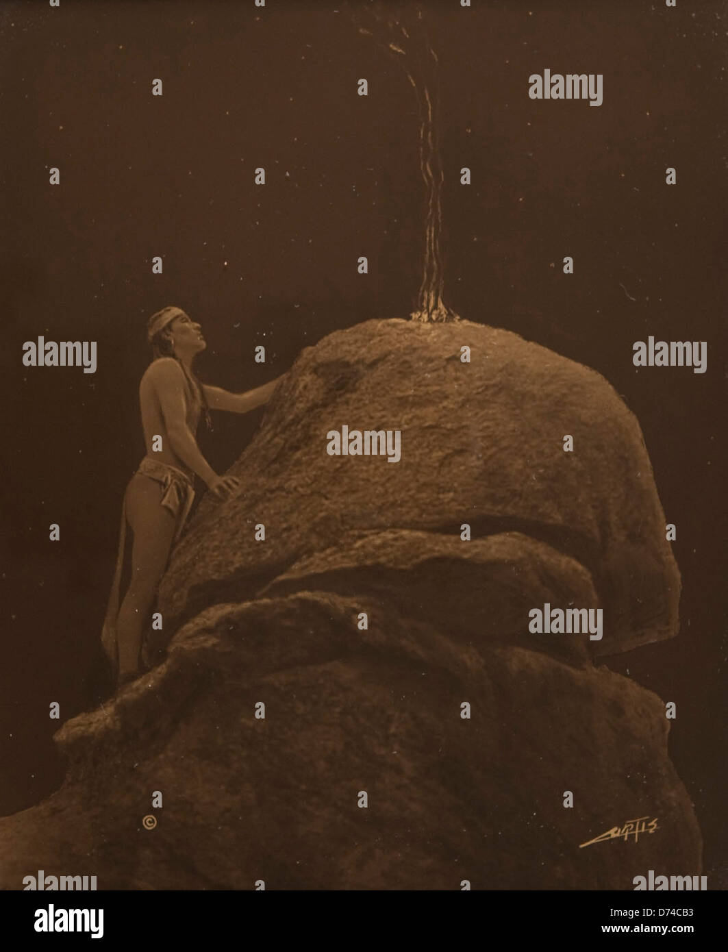Edward Sheriff Curtis hat auf diesem Foto ein indianisches Ritual festgehalten, in dem ein Signalfeuer an den Berggott gesendet wurde. Das Bild spiegelt die spirituelle Verbindung zwischen indigenen Völkern und der natürlichen Welt wider. Stockfoto