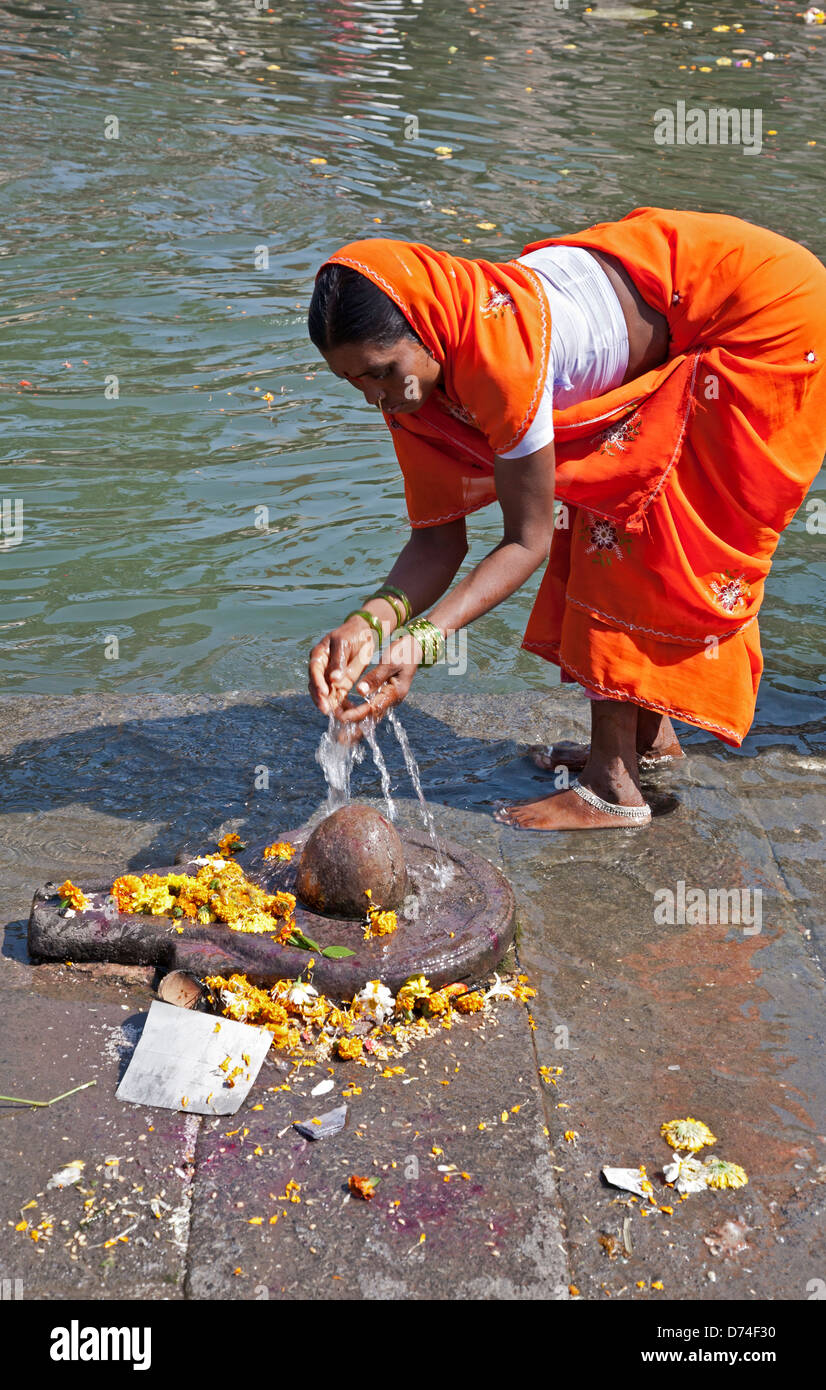 Hindu-Frau mit Wasser zu einem Shiva Linga. Godavari Fluß. Nasik. Indien Stockfoto