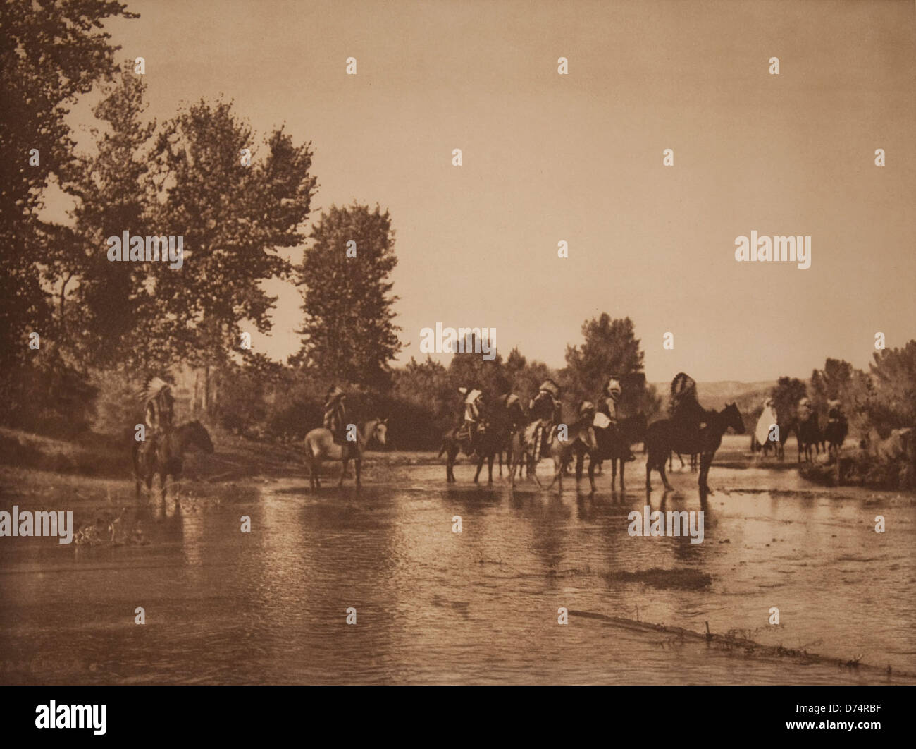 Dieses Foto mit dem Titel *at the Ford* ist Teil einer Sammlung im Cheyenne Museum of Photographic Arts, die historische Ereignisse und das kulturelle Erbe durch die Linse der Fotografie des frühen 20. Jahrhunderts reflektiert. Stockfoto