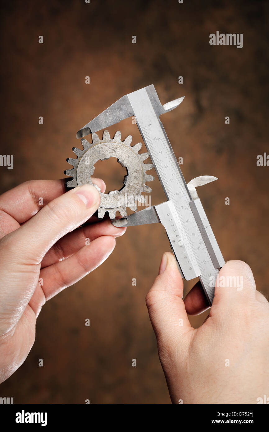 Messung des Durchmessers der alten Zahnradbahn mit Vernier Bremssattel Mann. Stockfoto