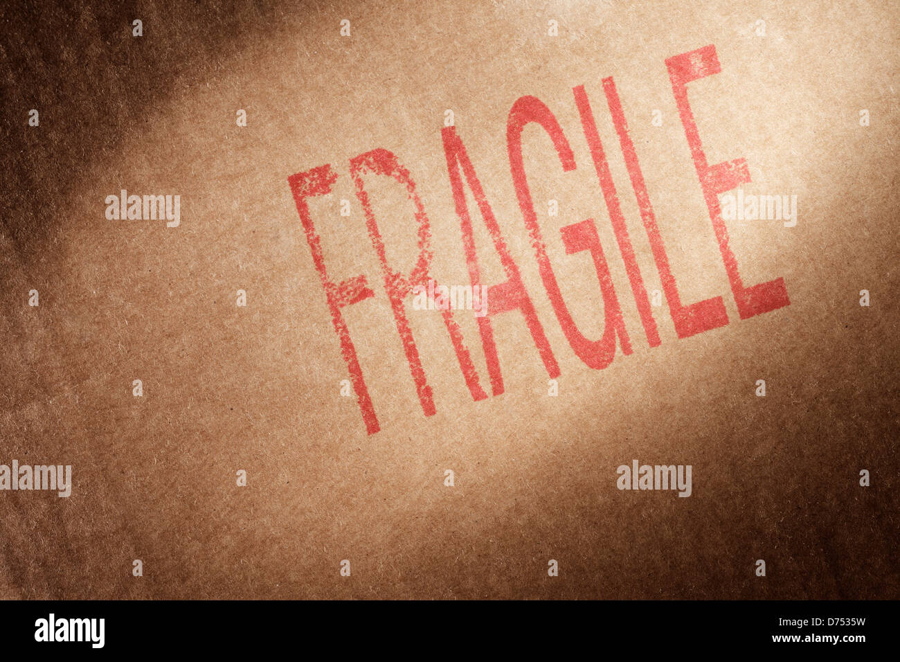 Nahaufnahme von einem braunen Karton mit Wort "Fragile" gestempelt mit roter Tinte. Stockfoto