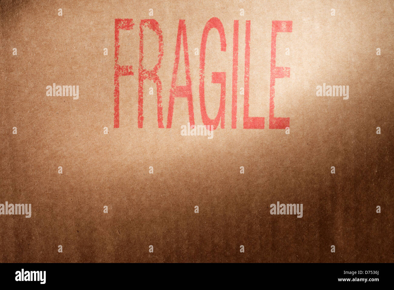 Nahaufnahme von einem braunen Karton mit Wort "Fragile" gestempelt mit roter Tinte. Stockfoto