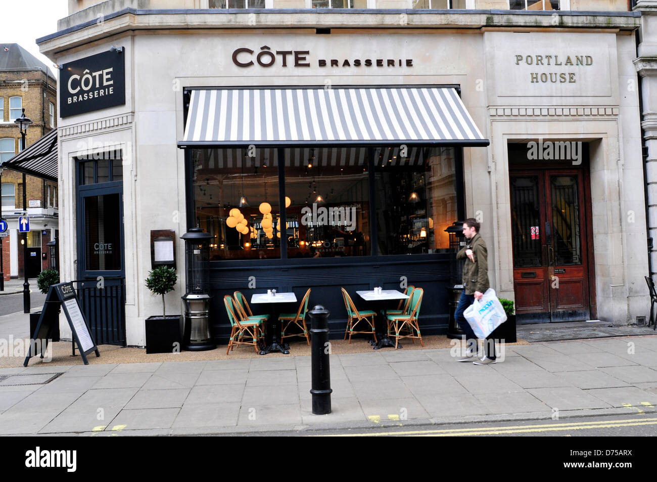 Ein Mann geht vorbei an Cote Brasserie, ein französisches Bistro in London, Vereinigtes Königreich. Stockfoto