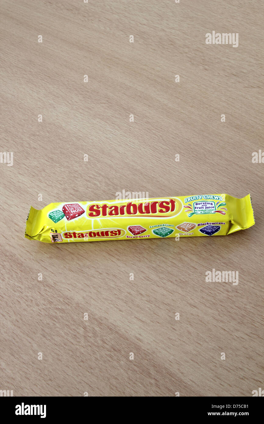 Paket von Starburst Süßigkeiten auf einem hölzernen Hintergrund Stockfoto