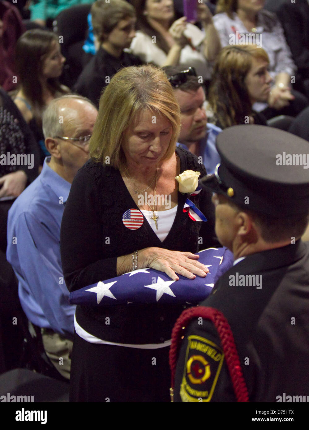 Mutter der Feuerwehrmann, der im Westen Texas Dünger Pflanze Explosion stirbt erhält eine gefaltete amerikanische Flagge bei Trauerfeier Stockfoto