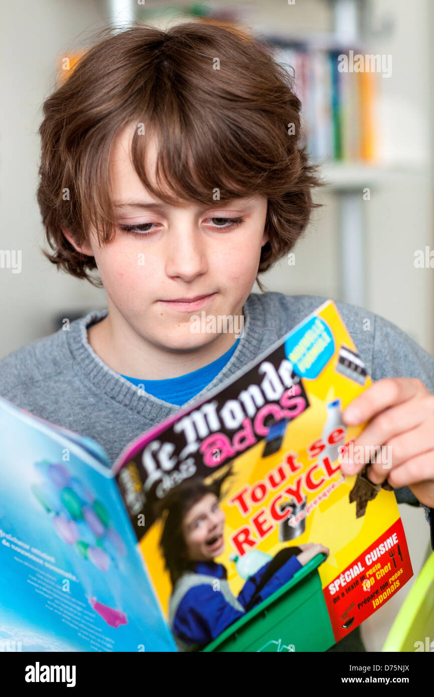 12 Jahre alter Junge, ein News-Magazin zu lesen. Stockfoto