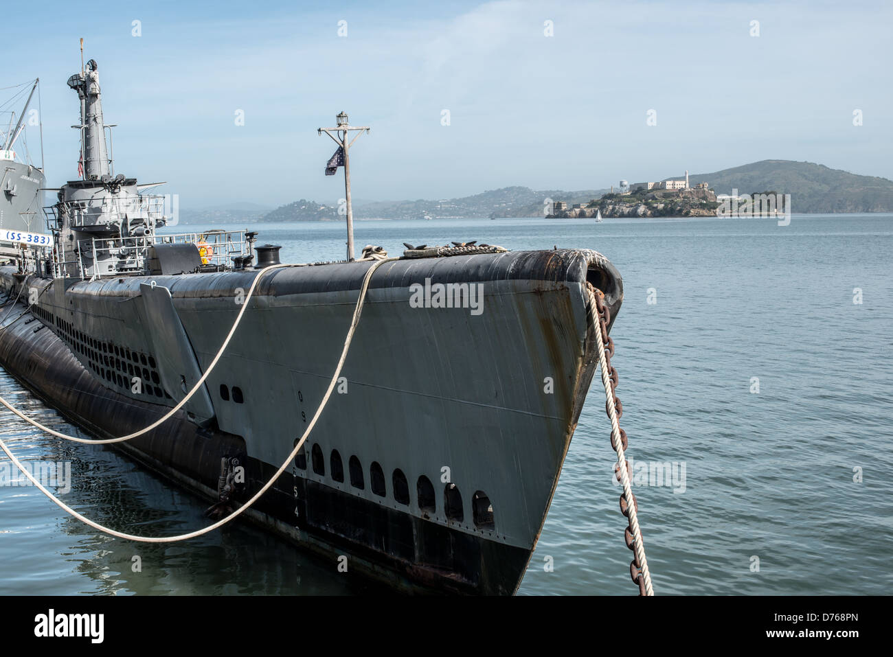 SAN FRANCISCO, Kalifornien - Im Vordergrund steht die USS Pampanito (SS-383), offen für öffentliche Besucher und auf San Francisco Fisherman's Wharf festgemacht. Im Hintergrund ist die Insel Alcatraz in der Bucht von San Francisco. Stockfoto