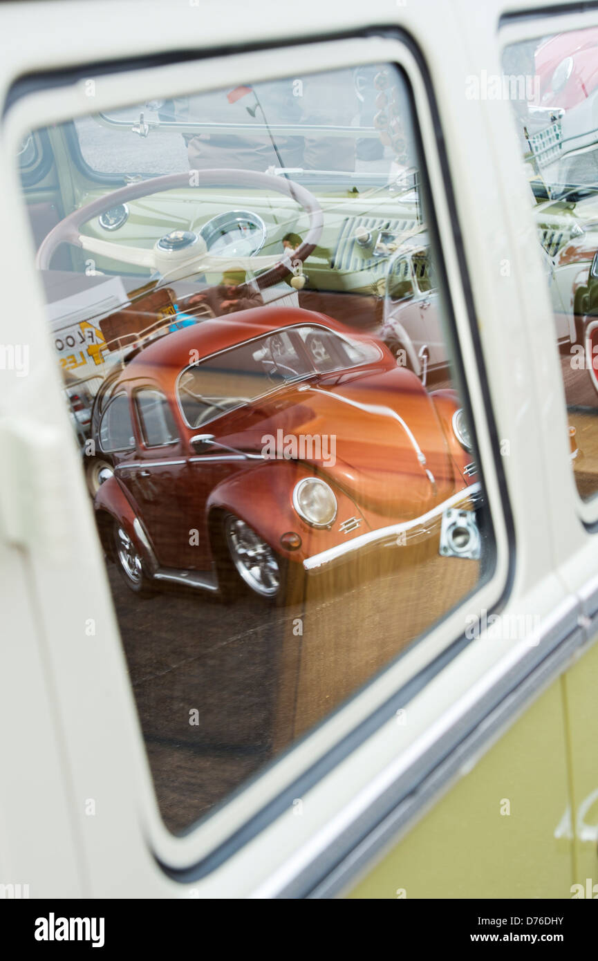 VW Käfer Auto spiegelt sich im Fenster des VW Volkswagen Wohnmobil Stockfoto