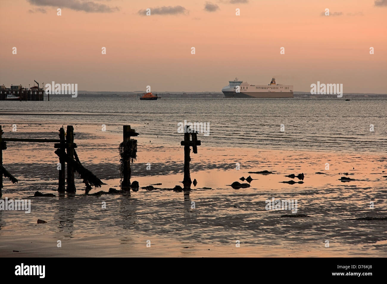 Landschaft Foto aufgenommen am Spurn Point zeigt Buhnen im Vordergrund und das Humber Rettungsboot und eine Fähre in der Ferne. Stockfoto