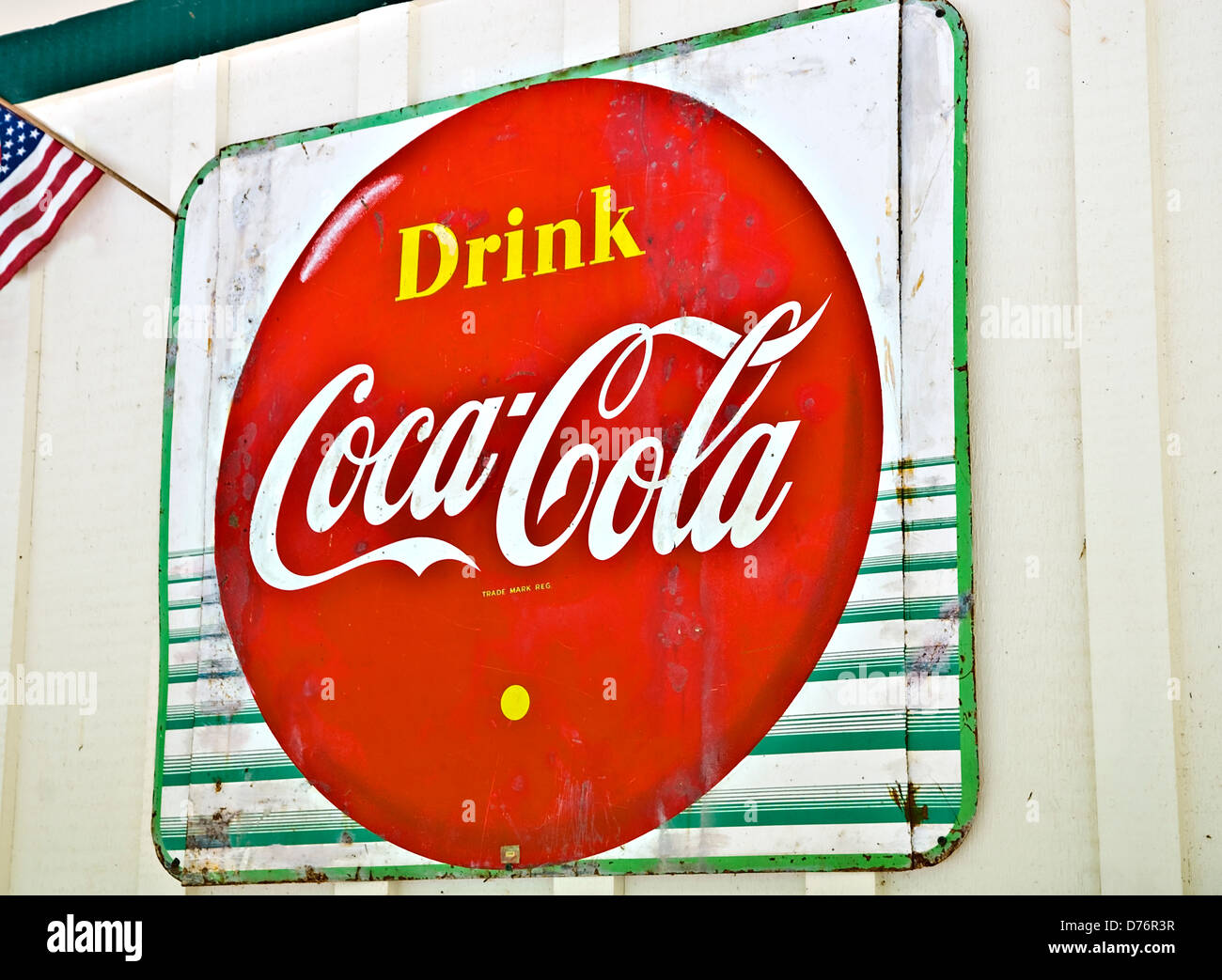 Ein altes Metall Coca-Cola Schild an der Seite eines Gebäudes. Stockfoto