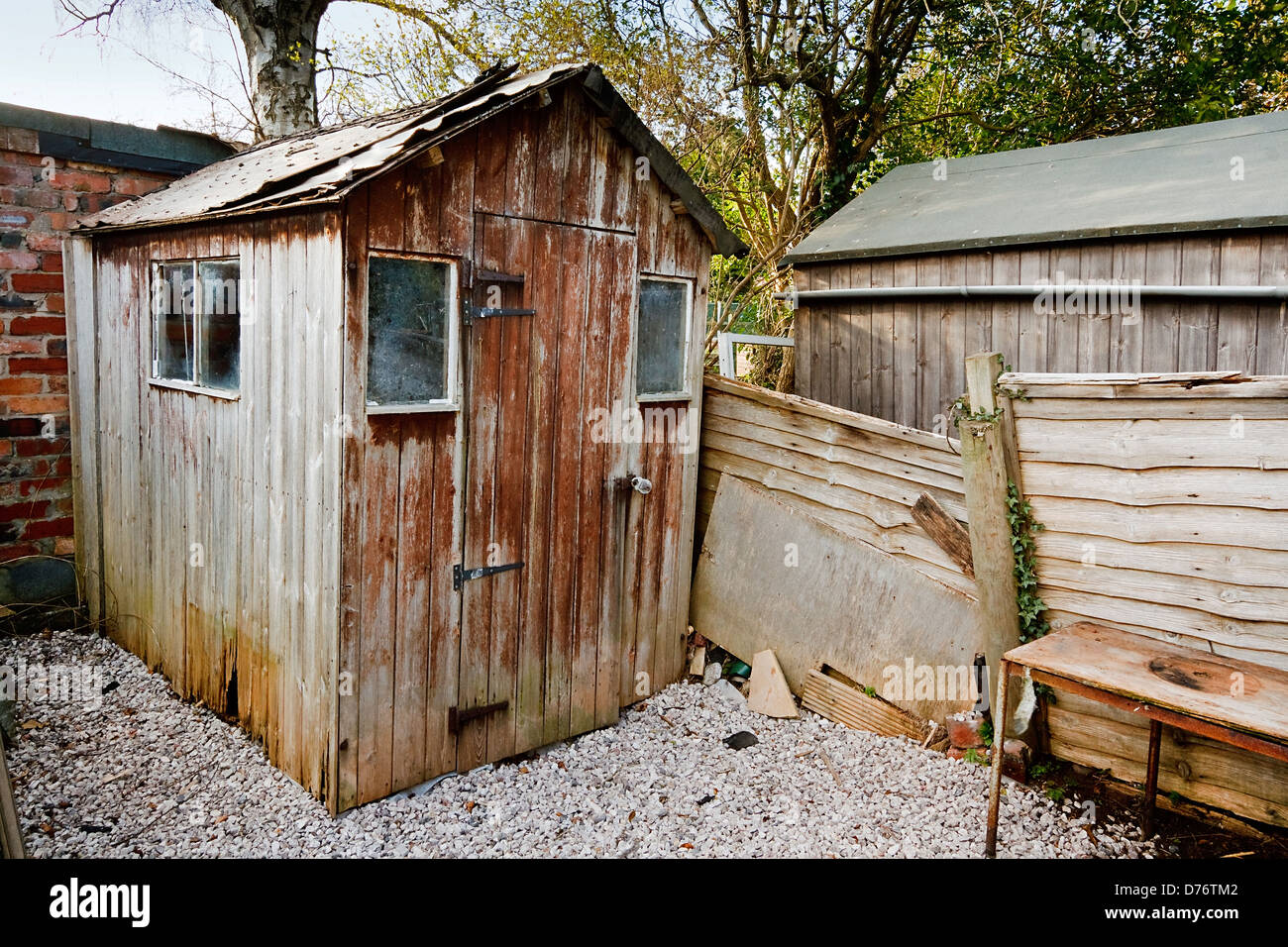 schlecht gepflegt alt gealtert heruntergekommen Sackleinen Panel hölzernen Gartenhaus mit beschädigten Dach und Loch aus hölzerne Fäule Stockfoto