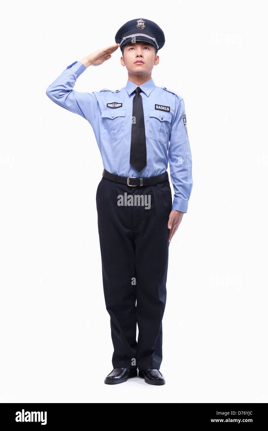 Polizist Saluting, Studioaufnahme, in voller Länge Stockfoto