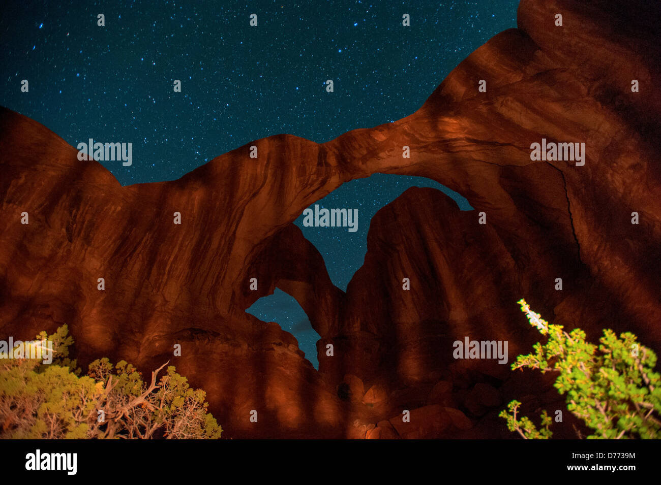 Doppelbogen beleuchtet mit Licht-Malerei am Nachthimmel voller Sterne Nacht overhead in Arches National Park in Utah. Stockfoto