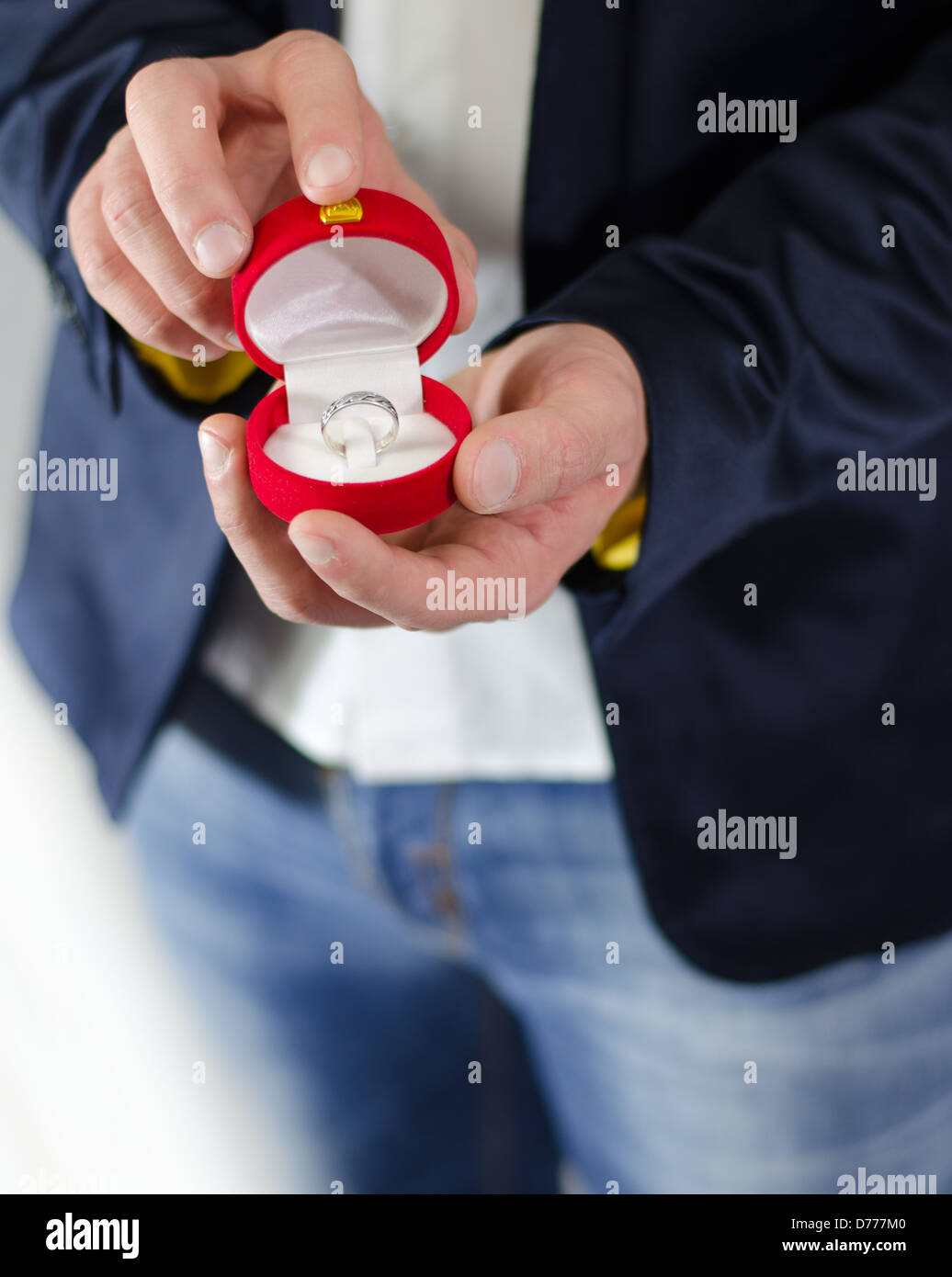 Verlobungsring oder Geschenk in den Händen eines Mannes im Anzug Stockfoto