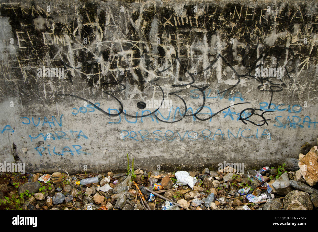 Grafity und Müll neben einer Wand Stockfoto