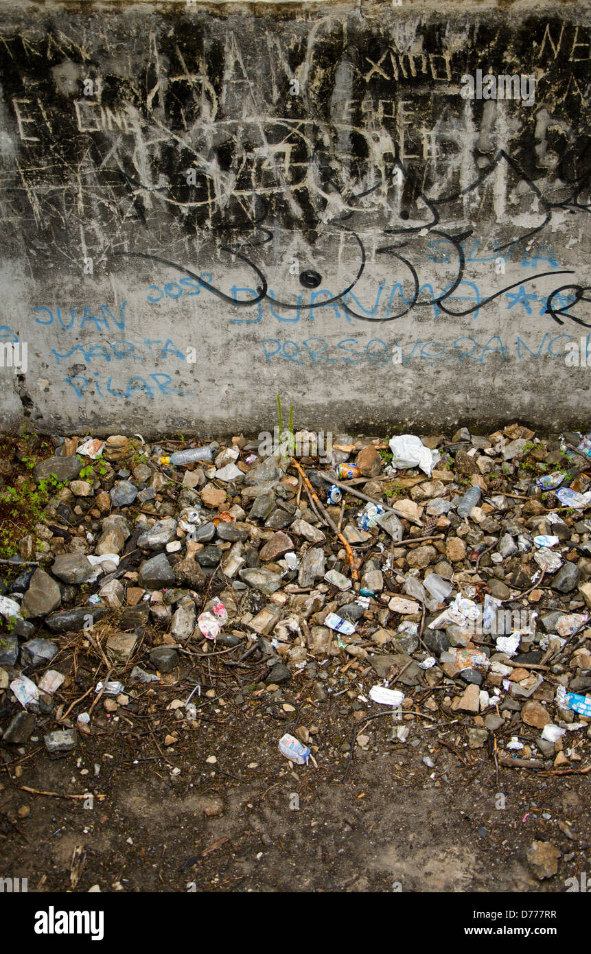 Grafity und Müll neben einer Wand Stockfoto