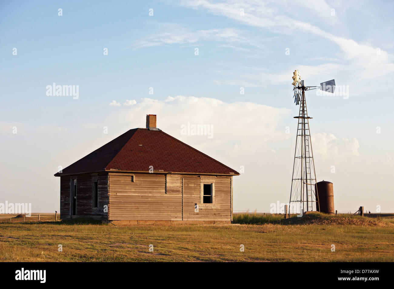 Windmühle, die Wasserpumpen neben verlassenen Ranch-Haus Stockfoto