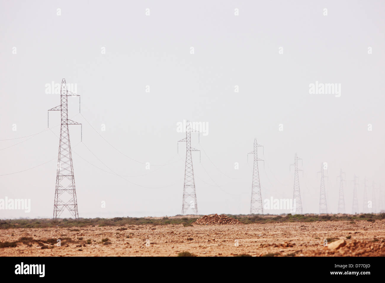 Harmattan Dunst verschleiert die Ansicht, dass Hochspannungsleitungen Linie Türme südwestlichen Marokko macht Stockfoto