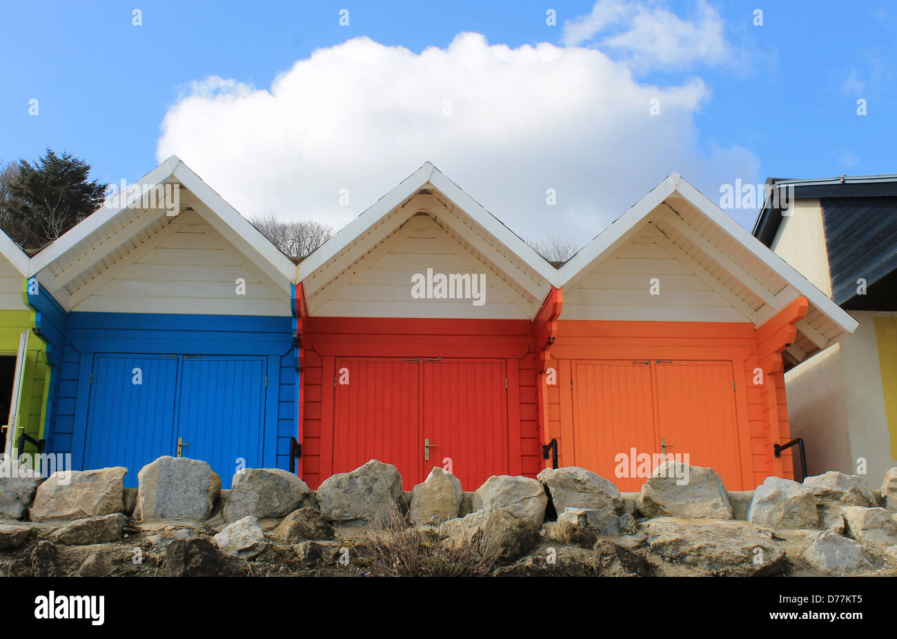 Reihe von bunten Beach Chalets mit blauem Himmel und Wolkengebilde Hintergrund. Stockfoto