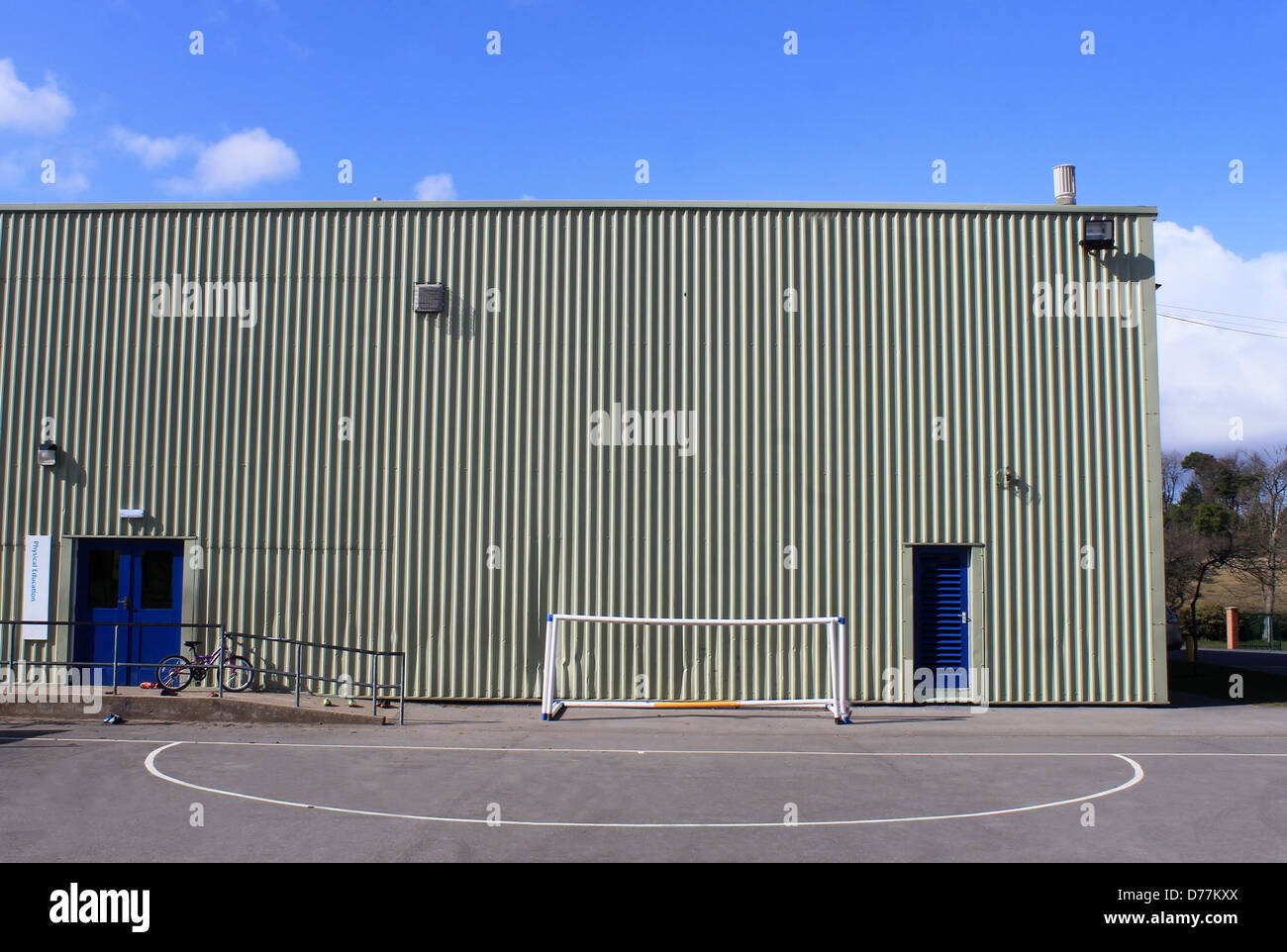 Exterieur der modernen Schule Sporthalle mit Ziel netto im Vordergrund. Stockfoto