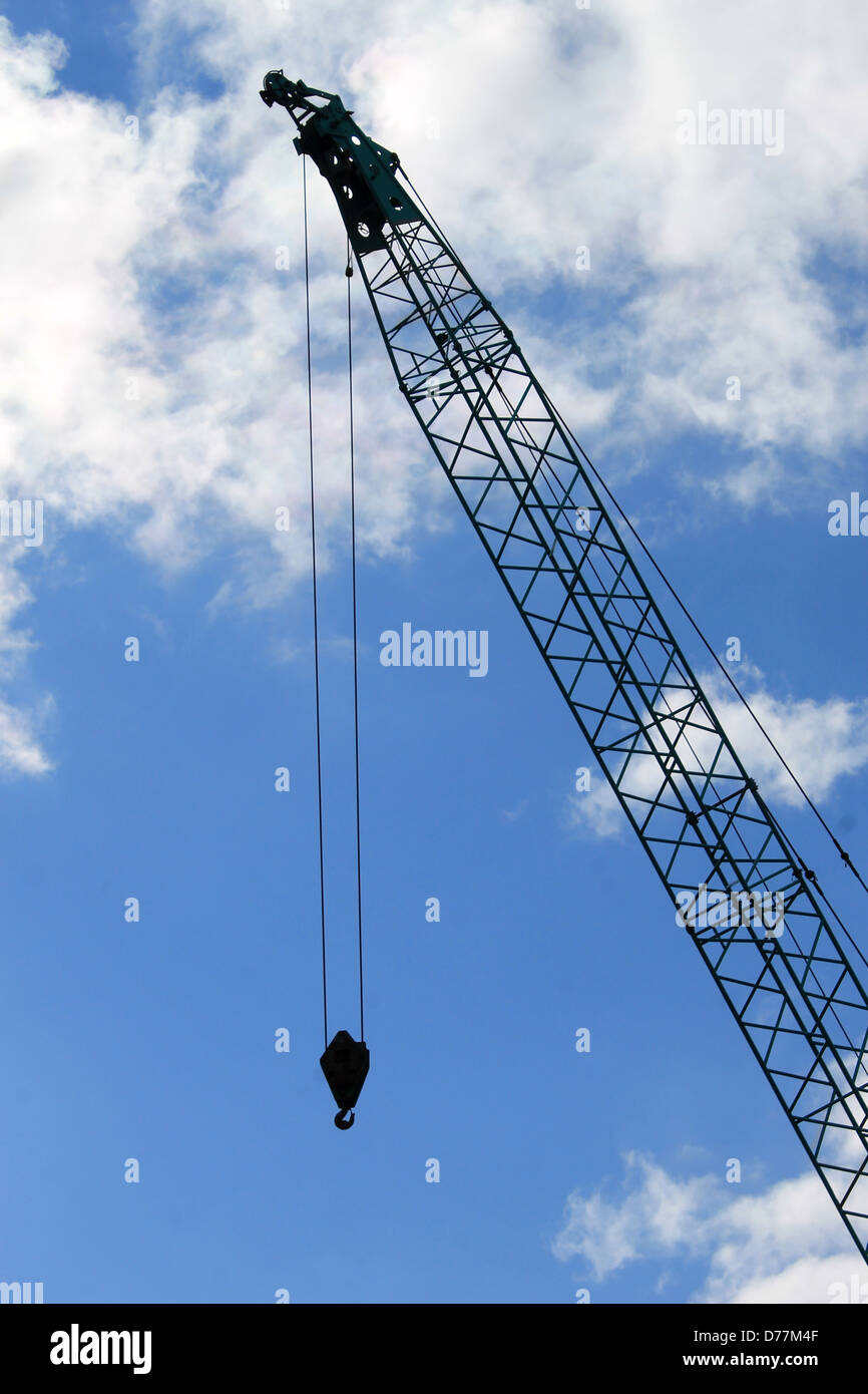 Silihouetted Kran mit blauem Himmel und Wolkengebilde Hintergrund. Stockfoto