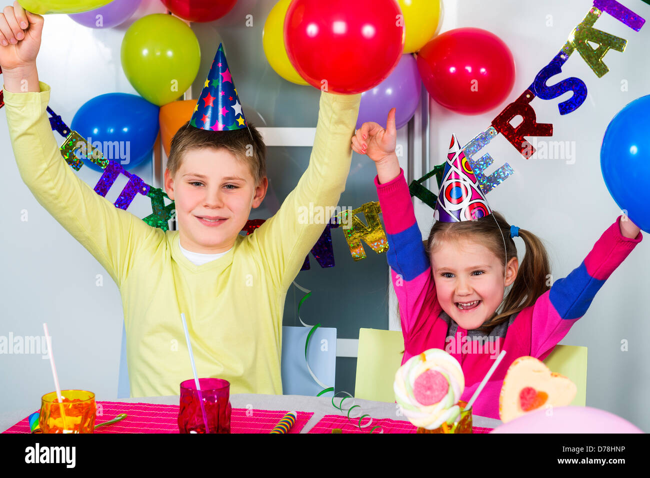 Glückliche kleine Kinder haben Spaß in einer Geburtstagsfeier Stockfoto