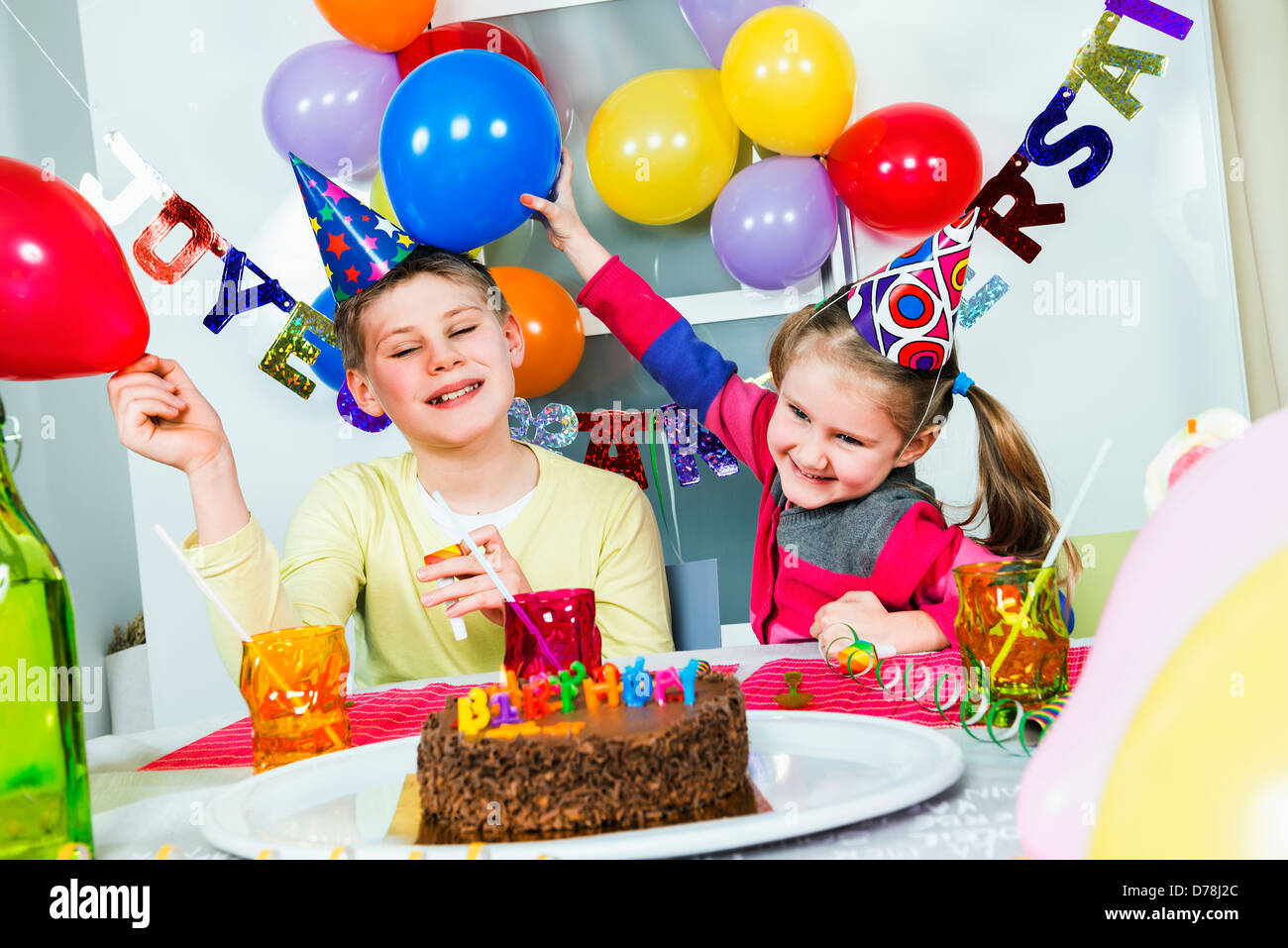 Glückliche kleine Kinder haben Spaß in einer Geburtstagsfeier Stockfoto