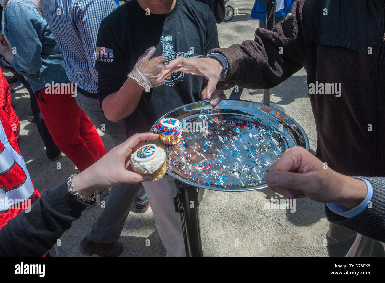 Glücklich Eishockey-Fans und andere Besucher erhalten kostenlose Werbe Cupcakes im Madison Square Park in New York Stockfoto
