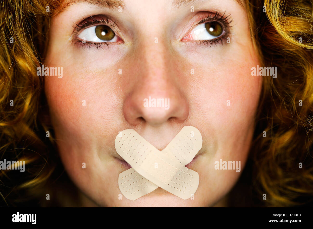 Frau mit Pflaster auf den Mund, symbolische Foto Rede Verbot, Frau Mit Pflaster Auf Dem Mund, Symbolfoto Redeverbot Stockfoto