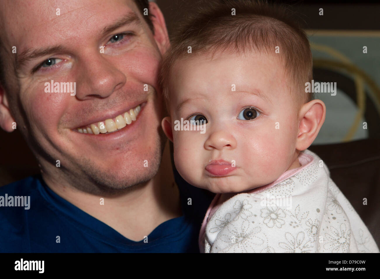 Ein Lächeln auf den Lippen Vater hält seine 5-Monate alten Tochter. Die Stockfoto