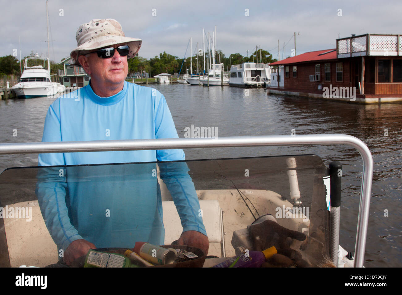 Ein Mann steuert ein Carolina Skiff aus dem Battery Park-Hafen in Apalachicola Bay, Florida, USA Stockfoto