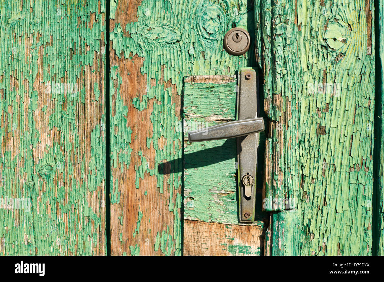 Alten Türgriff auf Holztür Hintergrund mit grüner Farbe rissig Stockfoto