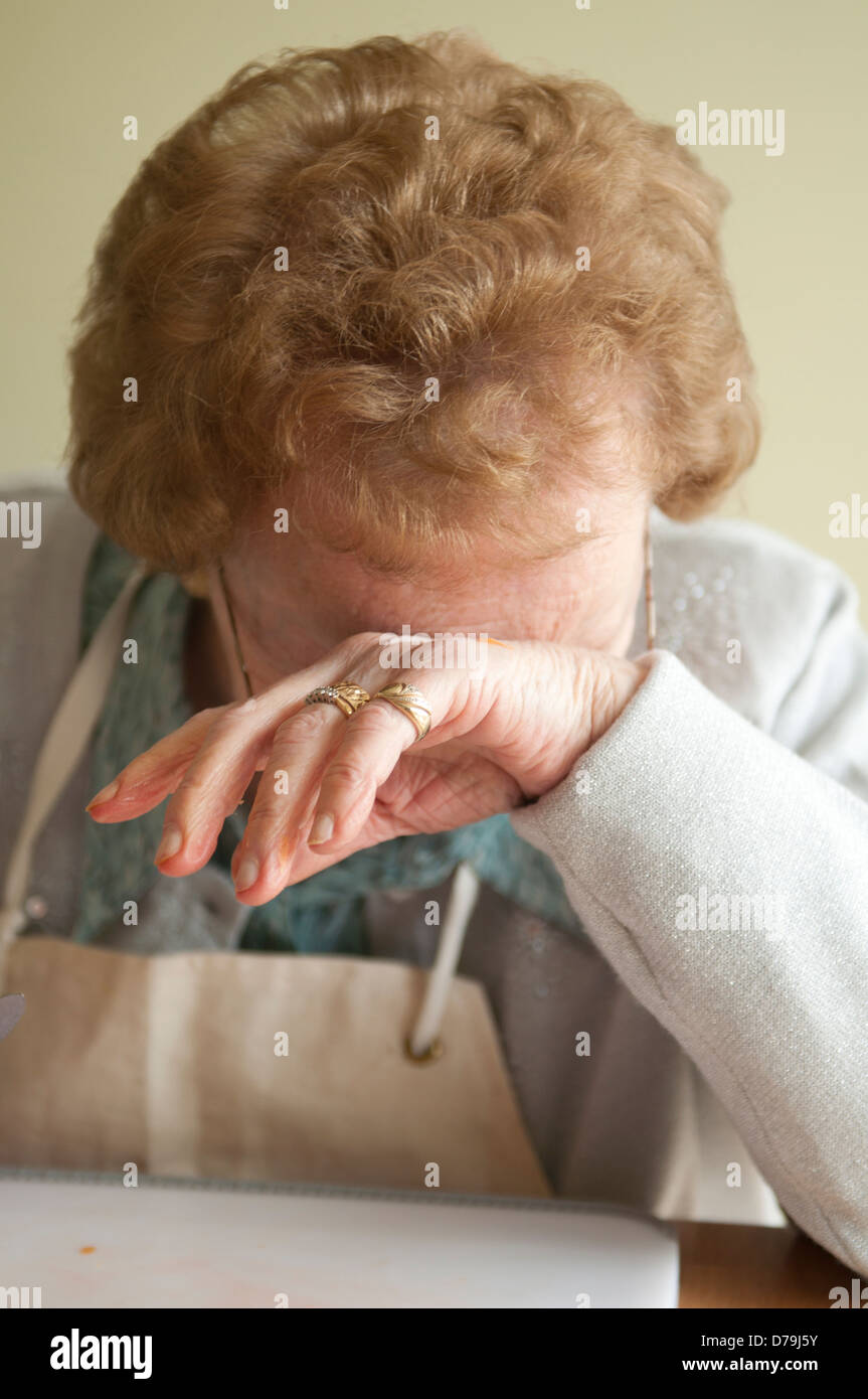 Ältere Frau weinen trägt Schürze Stockfoto