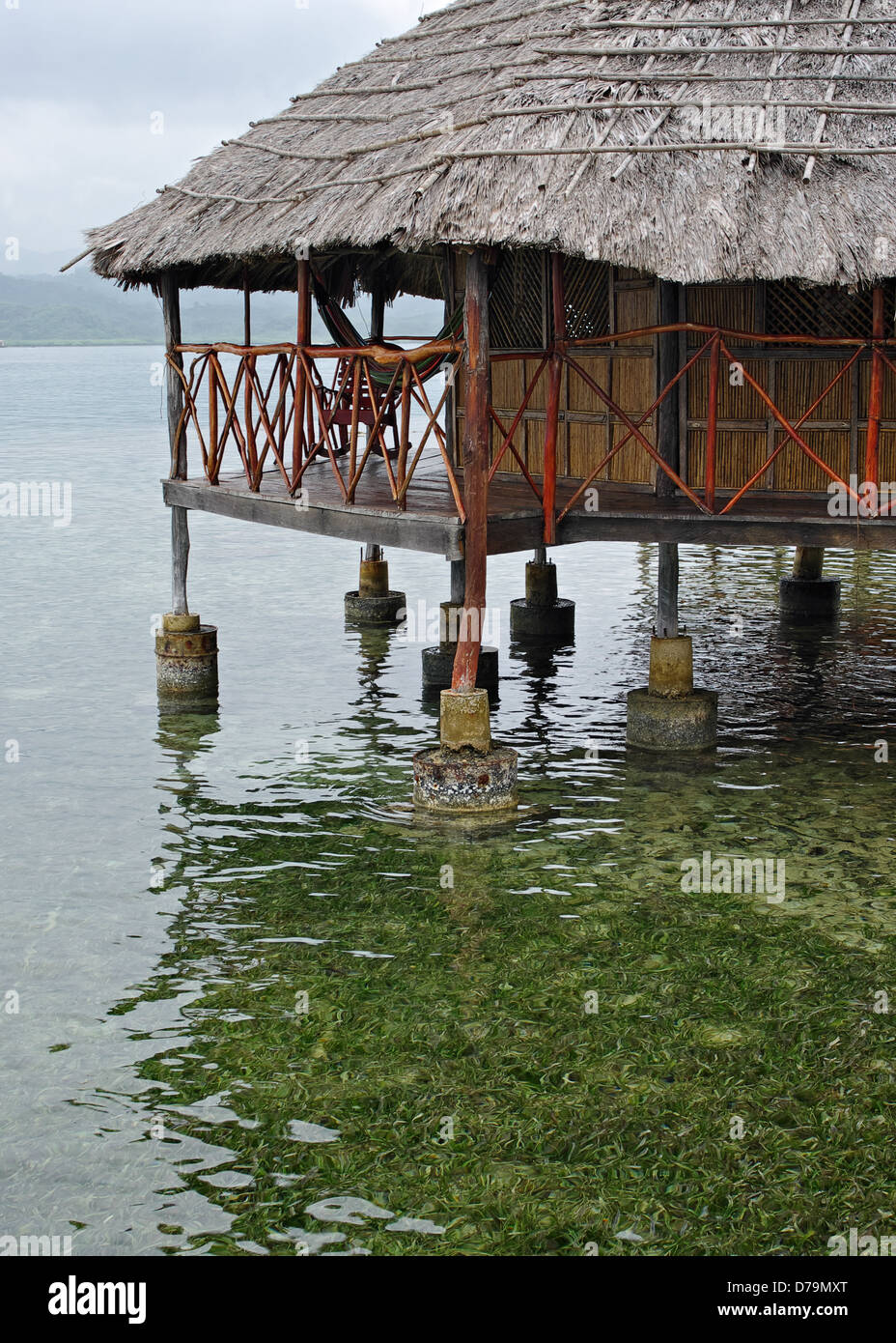 Eine strohgedeckte Hütte über Wasser in Kuna Yala in der Republik Panama. Stockfoto