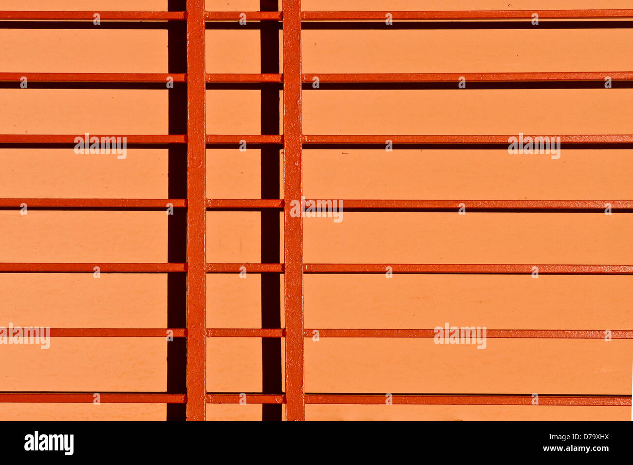 horizontale und vertikale orangen Balken auf ein helleres orange Wand horizontal Hintergrundbild Stockfoto